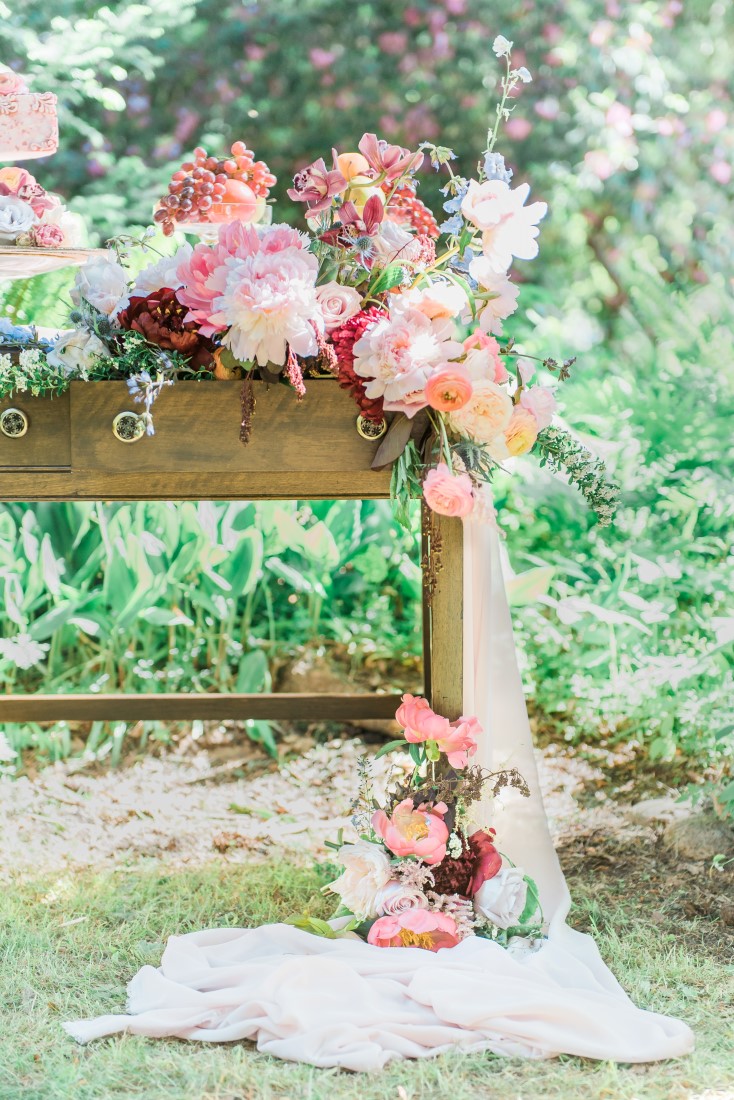 Flowers spill of table onto pooled white fabric in Vancouver park