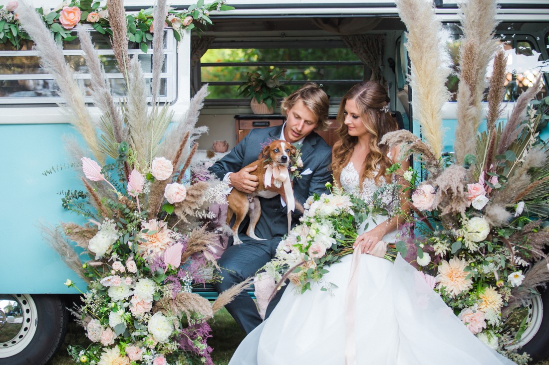 Volkswagon Photobus Elopement couple with dog and surrounded by flowers in Vancouver