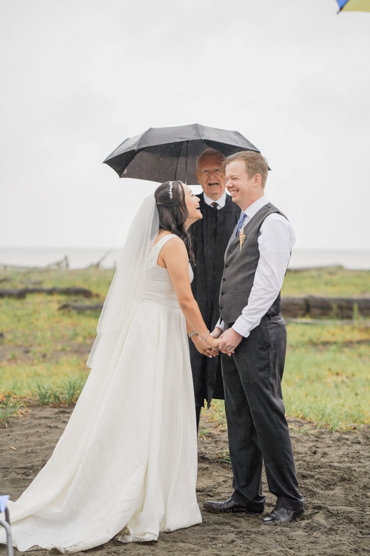 Bride and Groom seal their vows with a kiss under a black umbrella in Vancouver