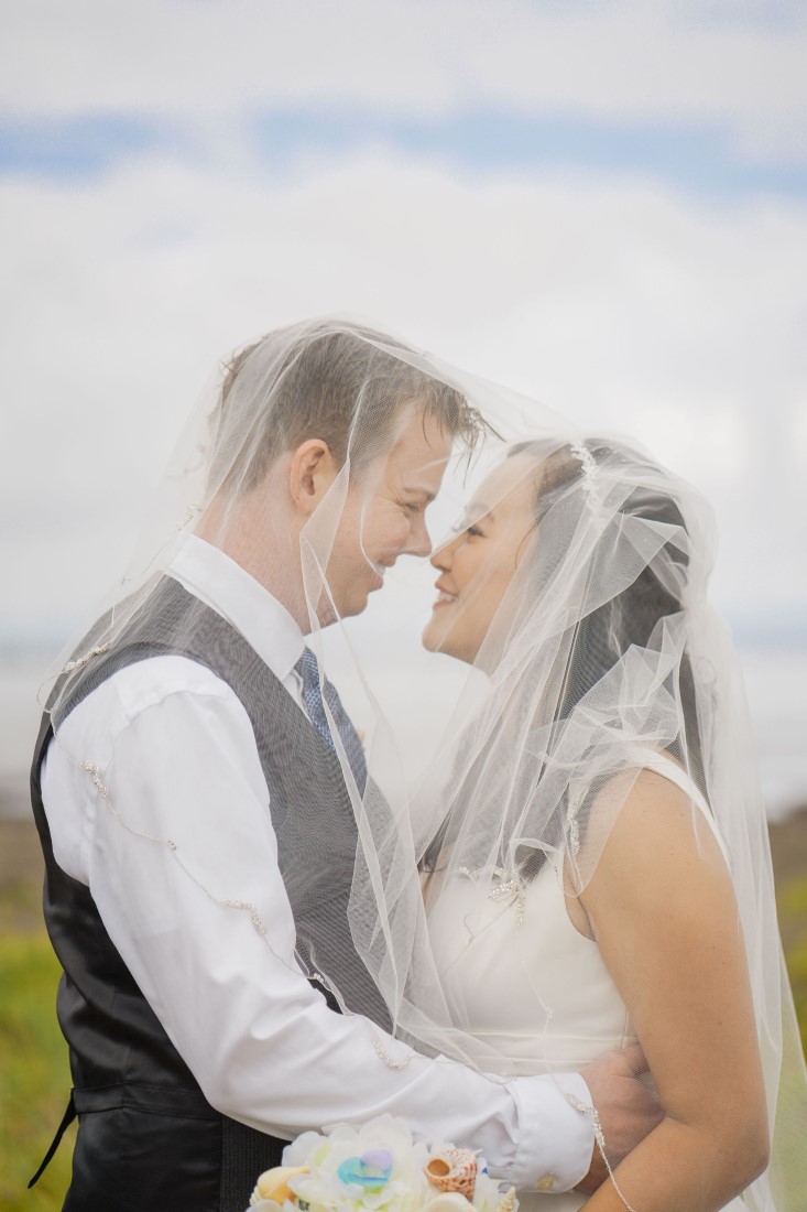 Bride and groom under veil by David's Bridal Vancouver 