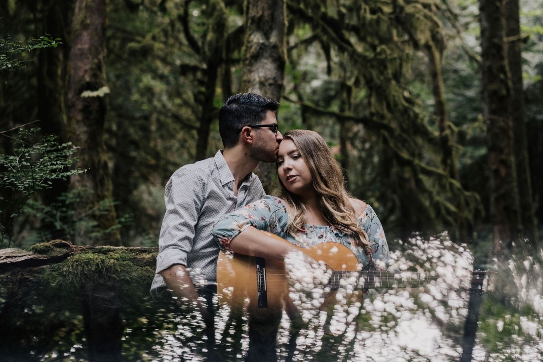 Couple embraces while playing guitar at Gowlland Tod Park on Vancouver Island