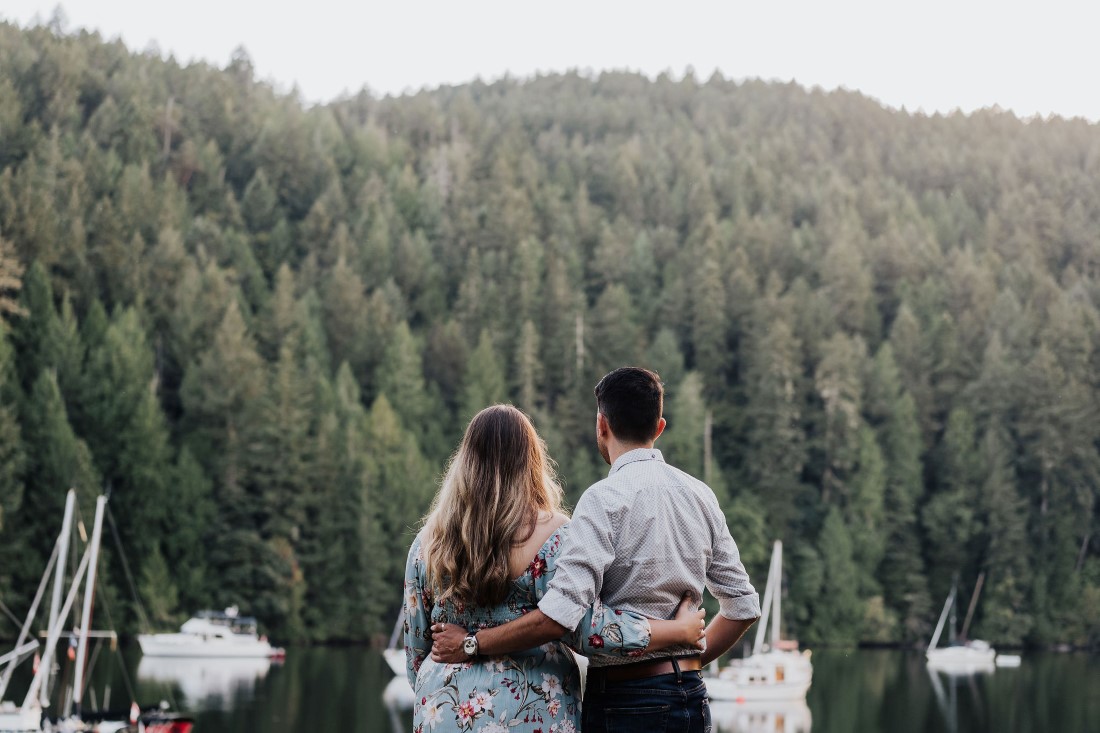 Couple looks out at forest and ocean together on Vancouver Island