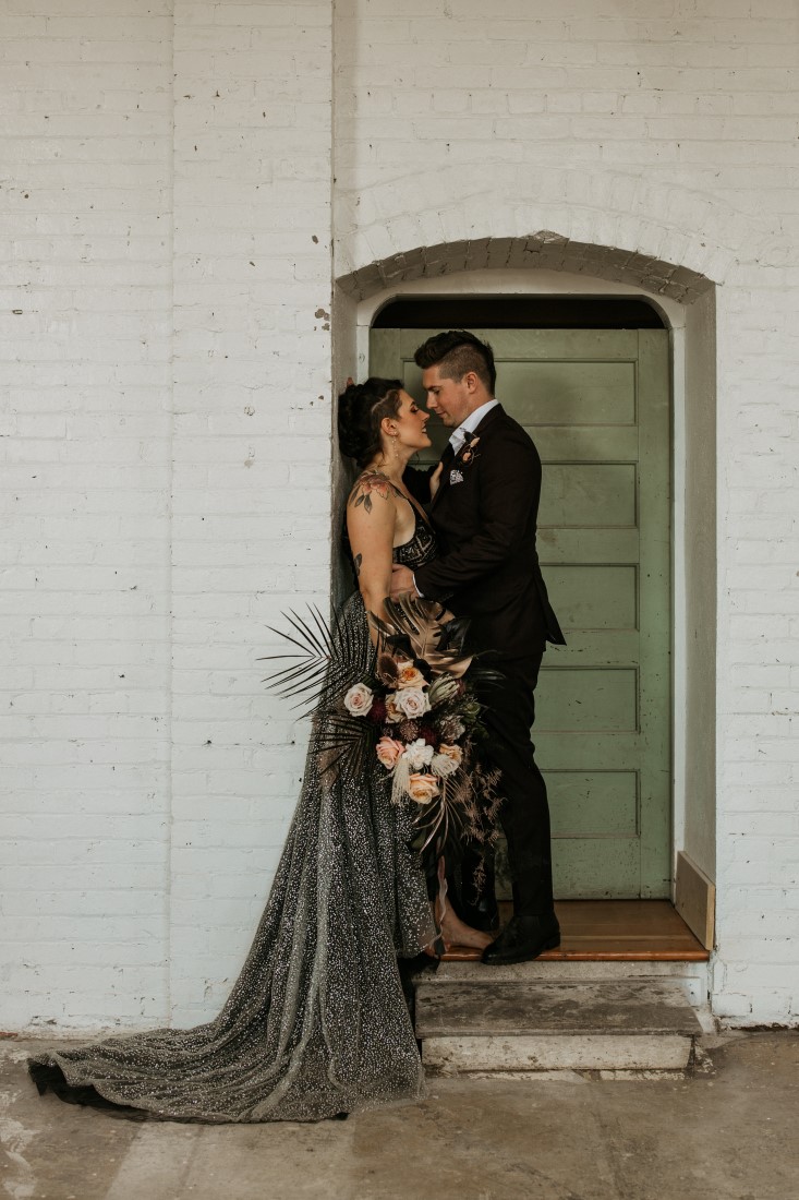 Bride amid Groom stand in the doorway