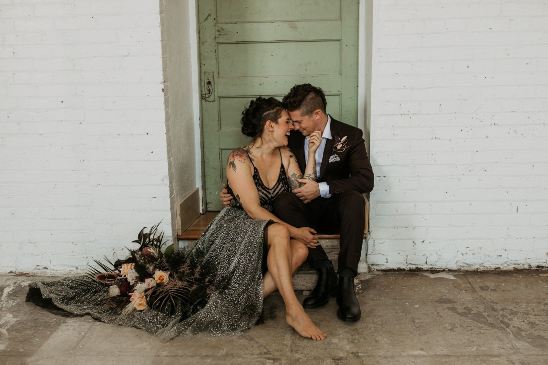 Newlyweds sit in vintage green doorway by Secret Waters Photography