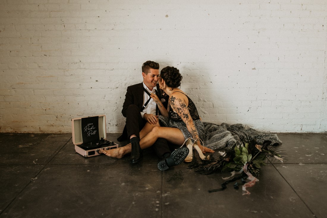 Bride kisses groom while they sit on the floor