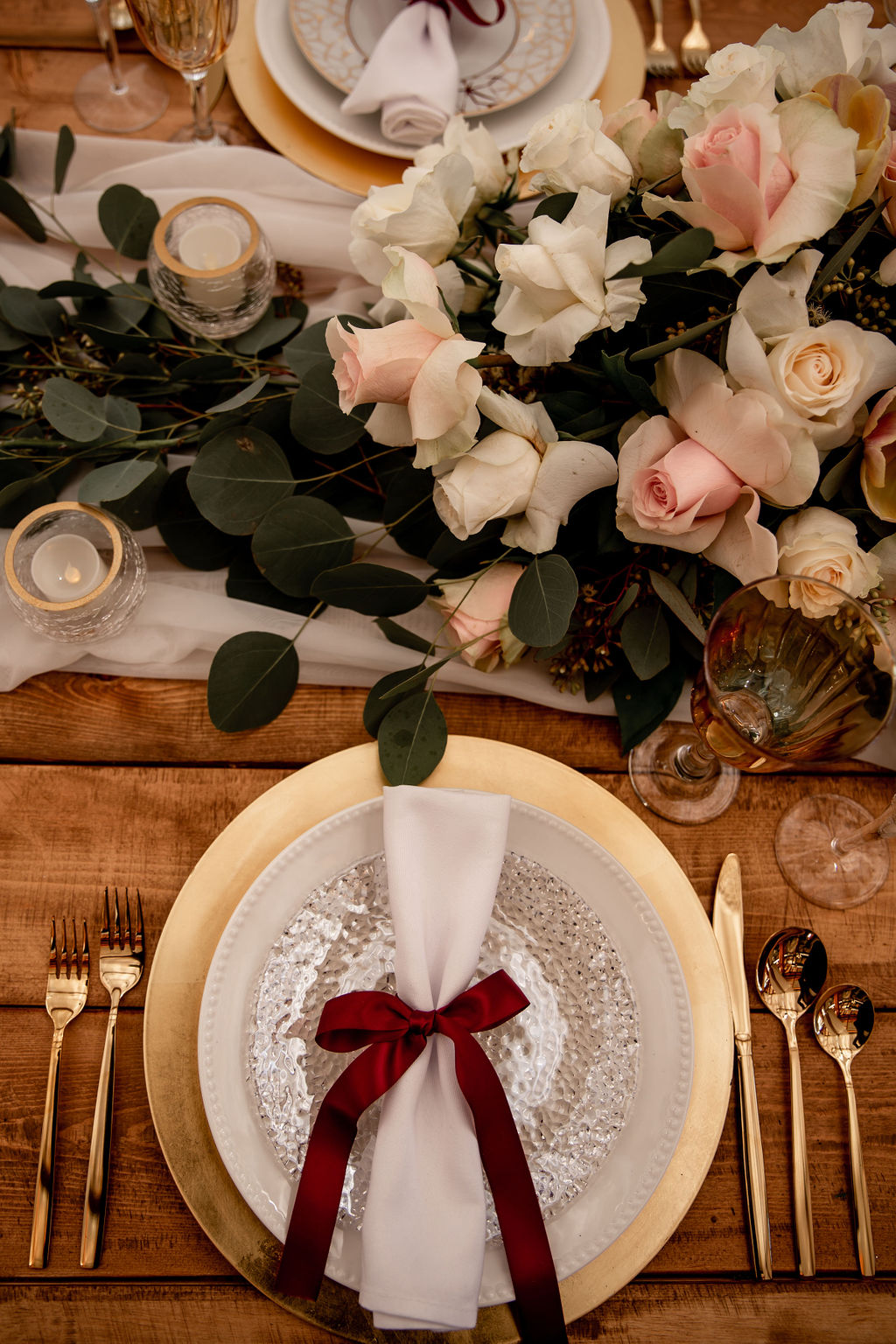 Burgundy ribbon around napkin on gold charger plate with pink orchids at Gateway Pacific Hotel Vancouver