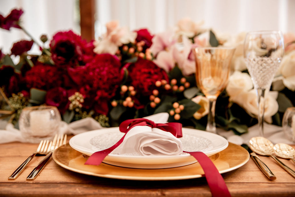 Napkin sits on gold charger with pink orchids behind at Pacific Gateway wedding 