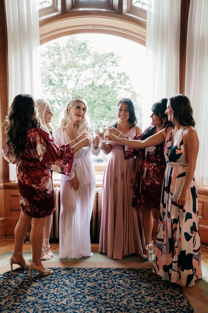 Bridesmaids help bride into her gown at Hatley Castle