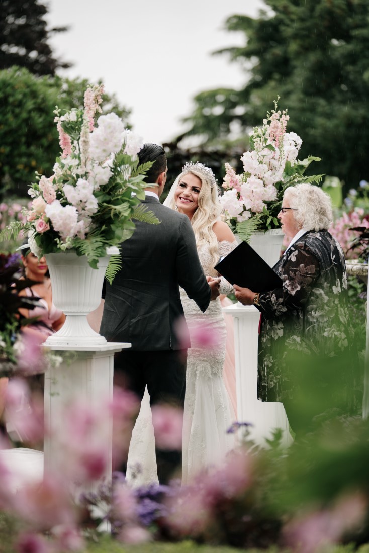 Bride and groom kiss after their vows at Hatley Castle Gardens