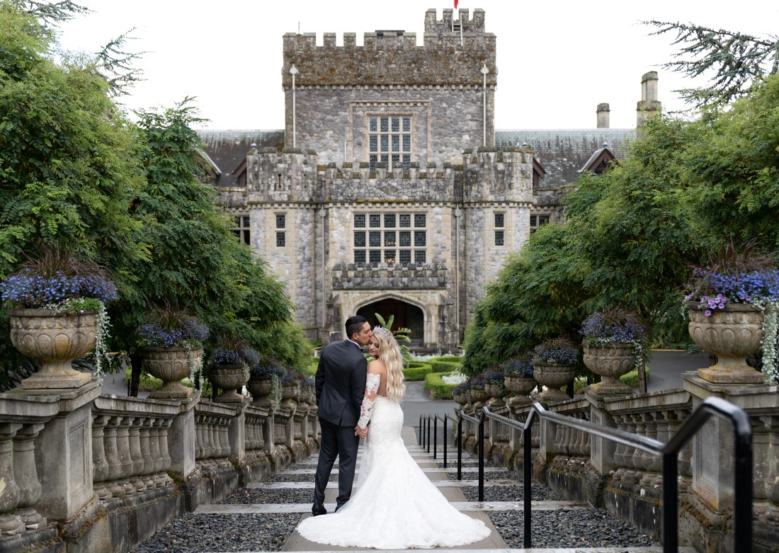 Newlyweds pose in front of Hatley Castle on Vancouver Island by Ross Kyker Photography