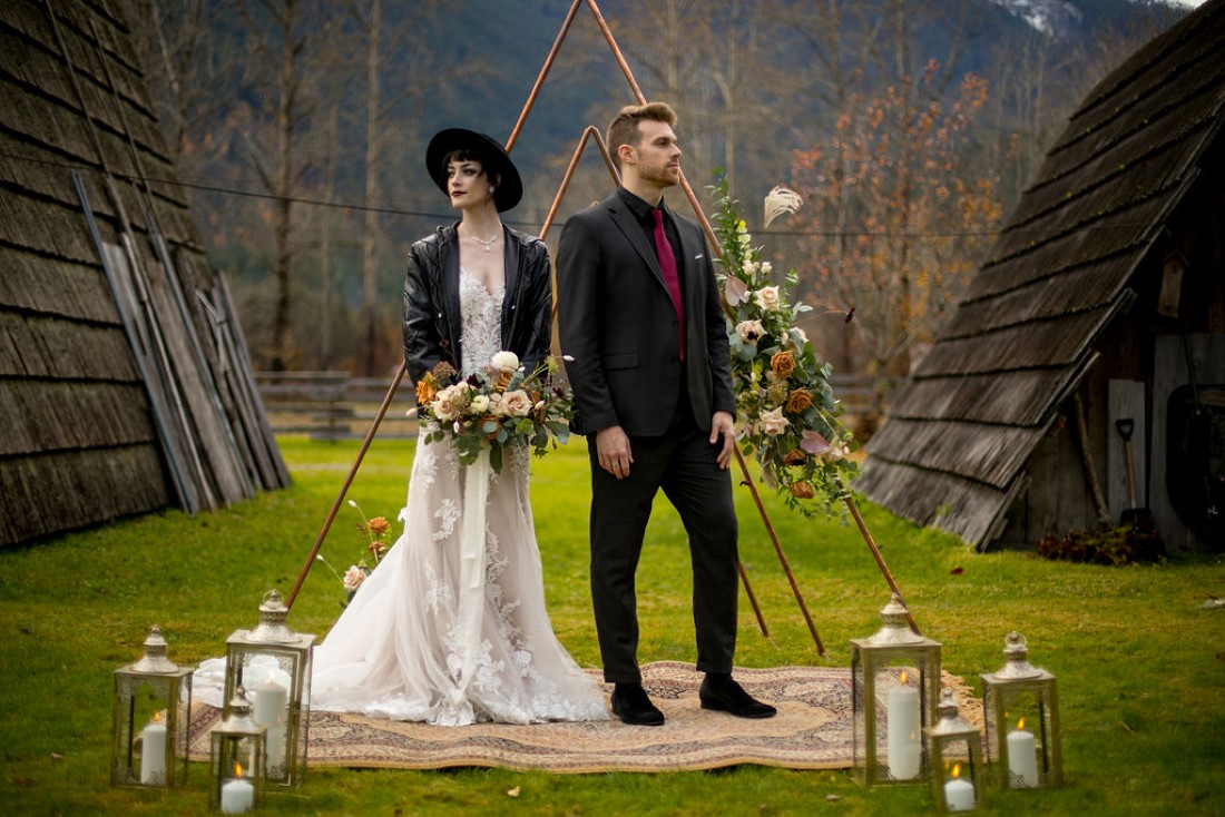 Bride and Groom in front of ceremony decor and backdrop of BC mountains