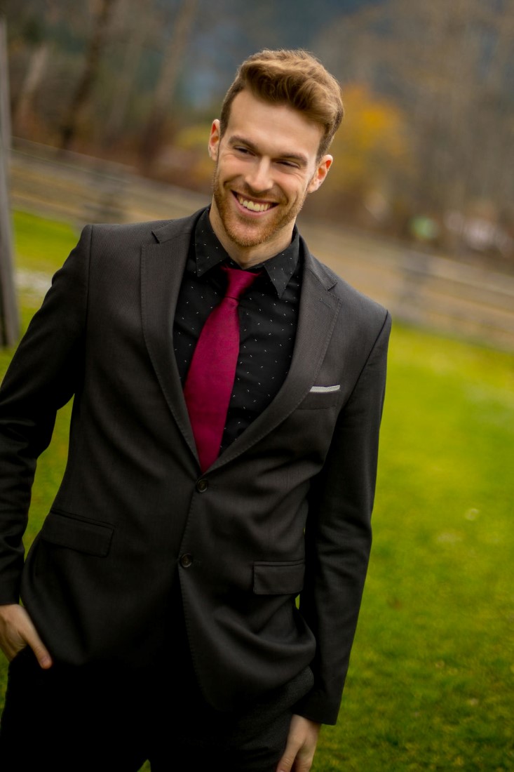 Groom in black suit and shirt with burgundy tie