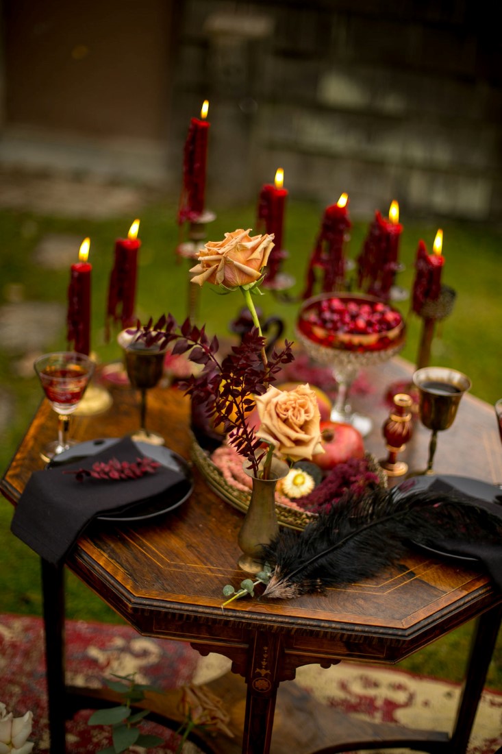 Tall candle sticks with burgundy candles and orange roses