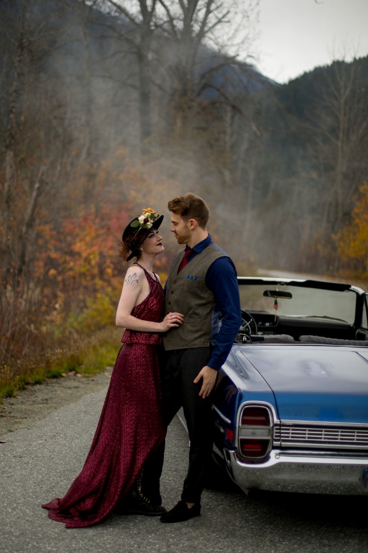 Newlyweds lean against blue classic car in Vancouver wedding