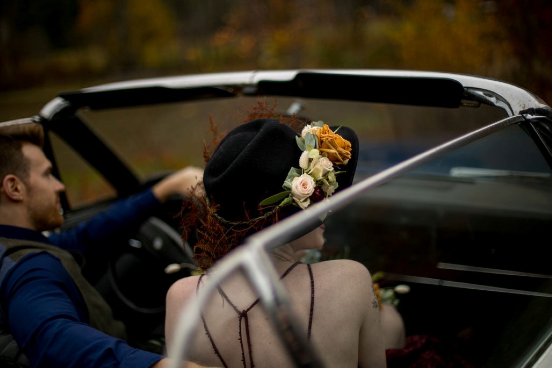 Bride wearing floral crown in classic car by Meghan Andrews Photography