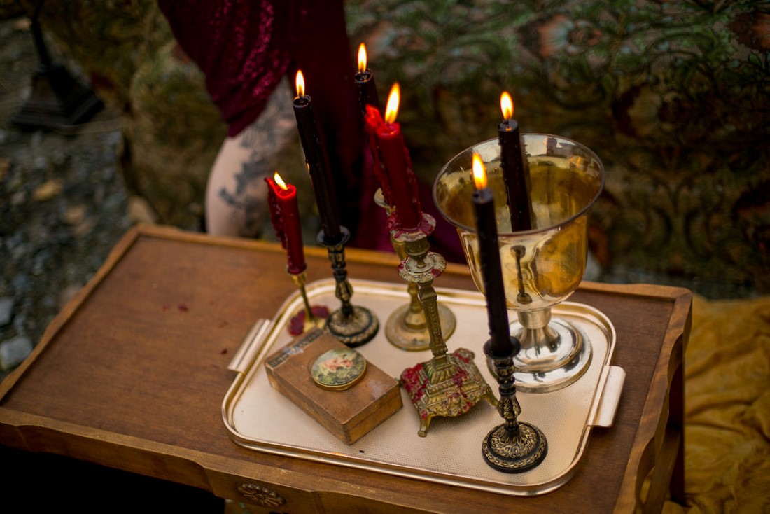 Burgundy candles in candelabras on wood table in British Columbia wedding