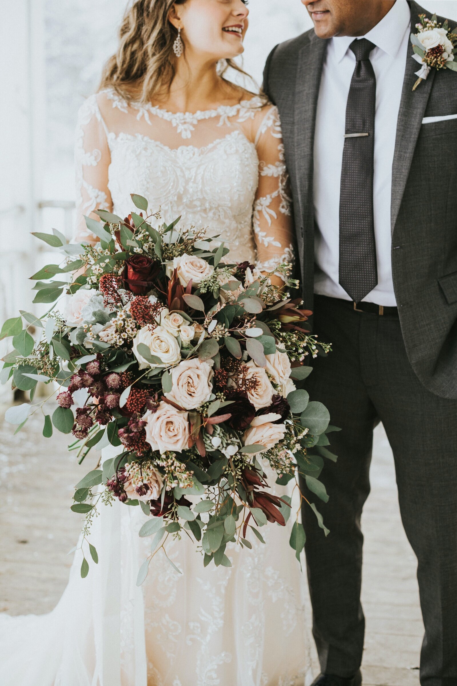 Bouquet of pink, white and burgundy roses, dusty miller, eucalyptus and wax flowers