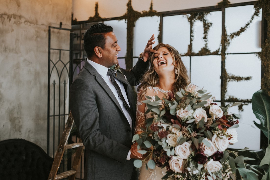 Newlyweds laughing as they take portraits 