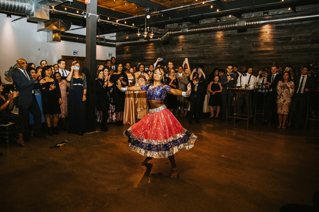 Indian girl in red skirt dances at fusion wedding