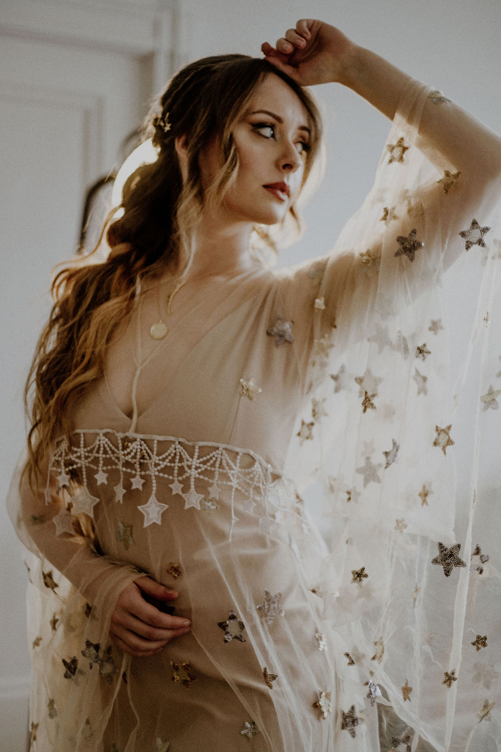 Bride shows off sheer butterly sleeves with gold stars on Flutter Dress Vancouver