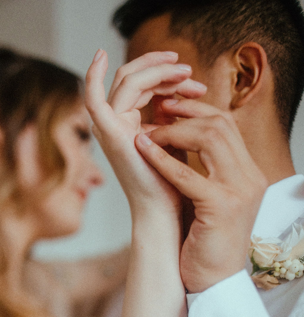 Bride and groom entwine hands by Sarah England Photography