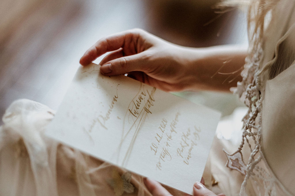 Bride looks at vows written in calligraphy by Penscription Vancouver