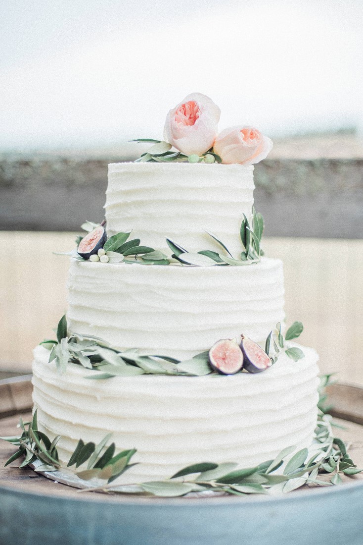 Three tiered wedding cake with greenery and blush pink roses by Taylor Made Cakes