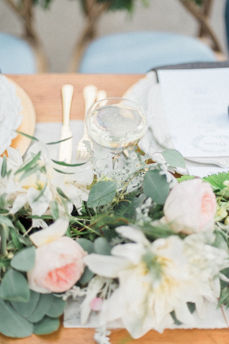 Sweetheart table wedding decor of blush pink roses and greenery