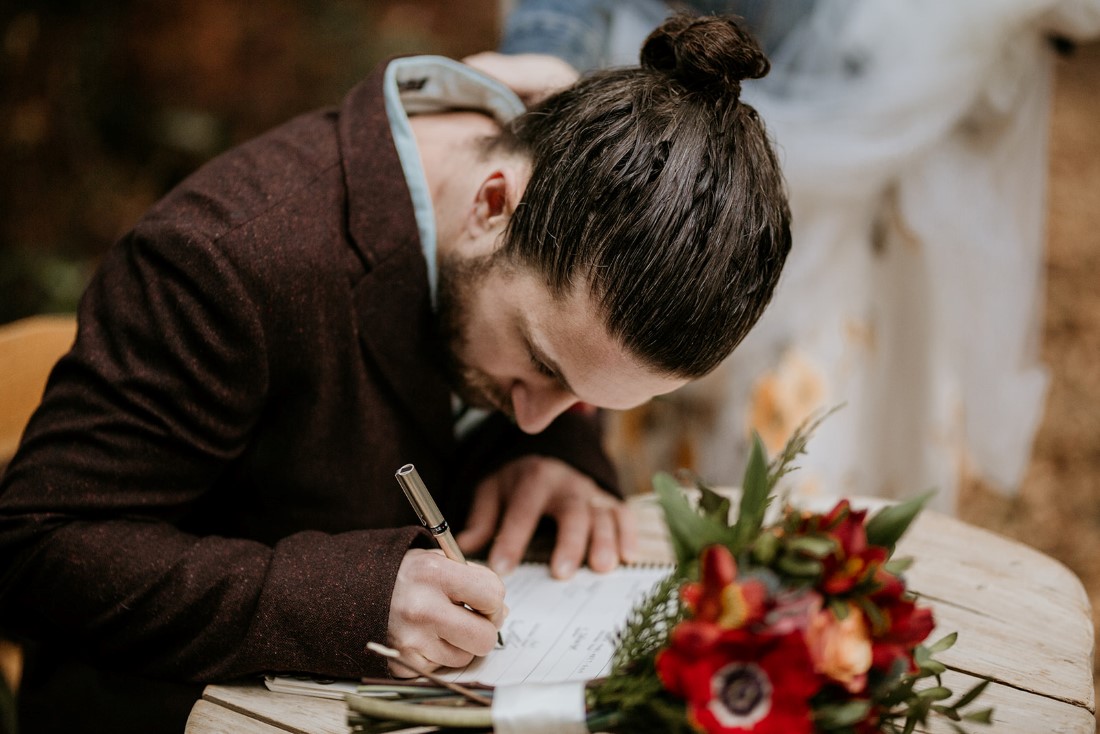 Groom signs paperwork after wedding ceremony at Wick Inn Tofino