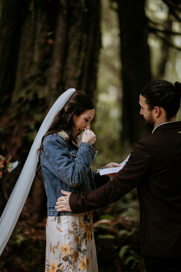 Bride weeps while sharing wedding vows during forest ceremony