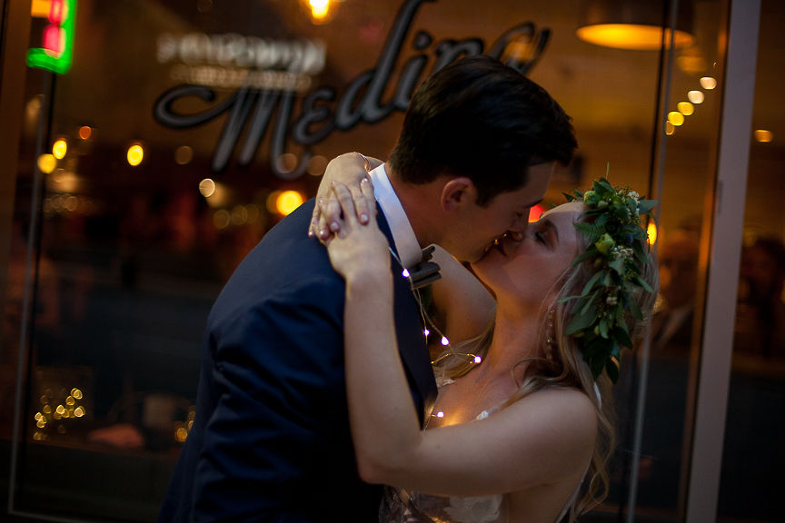 Romantic Wedding Day Newlyweds kiss under twinkle lights in Vancouver