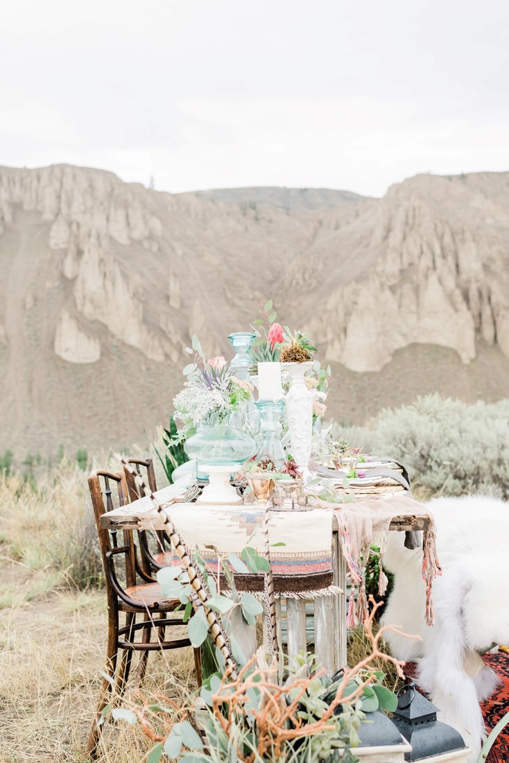 Tablescape with two brown chairs and a white fur sits by lake near Vancouver