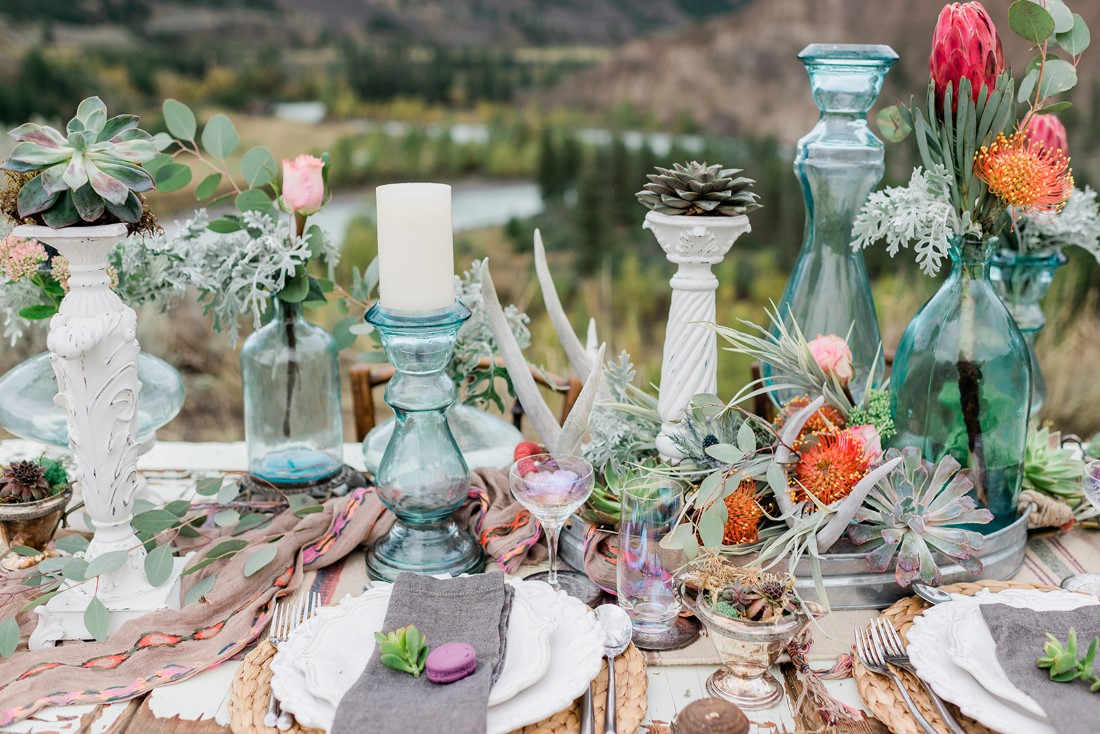 Boho inspired tablescape filled with orange flowers and candles