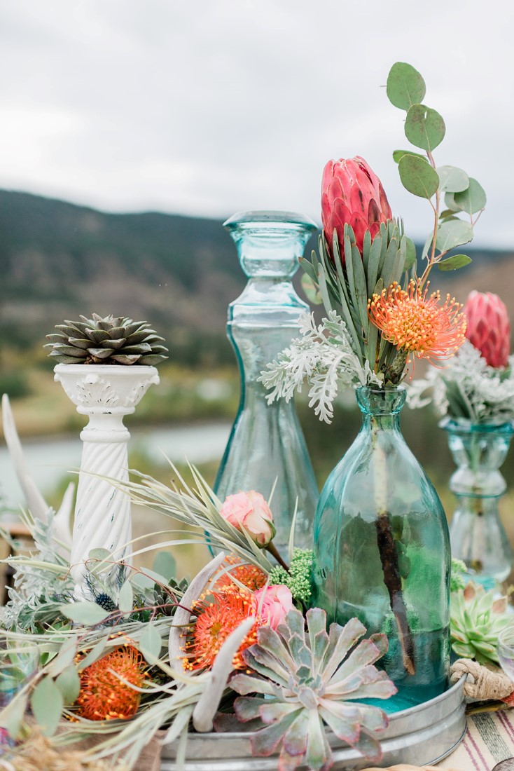 Orange and red flowers in green glass antique bottle