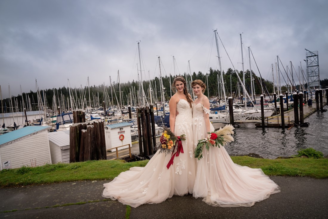 Brides pose in front of boats in Nanaimo marina 