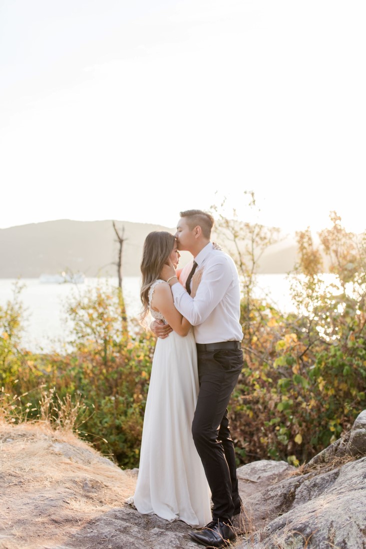 Whytecliff Park couple embrace among the grass during sunset