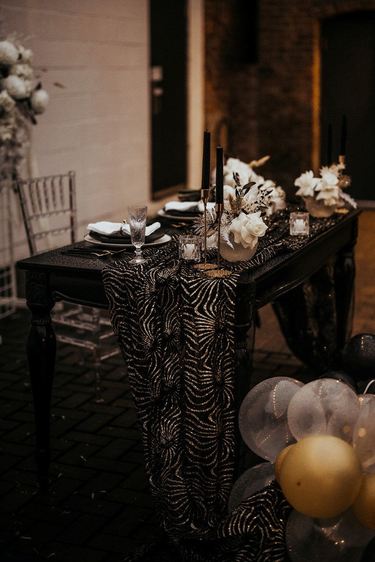 Sweetheart Table with black linens, gold cutler and white roses by En Vied Events