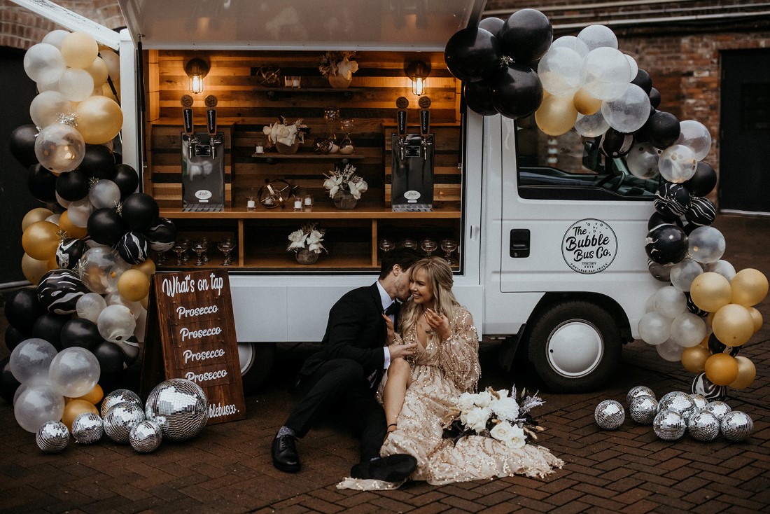 Romantic couple drinks prosecco in front of Bubble Bus Co Vancouver Island 