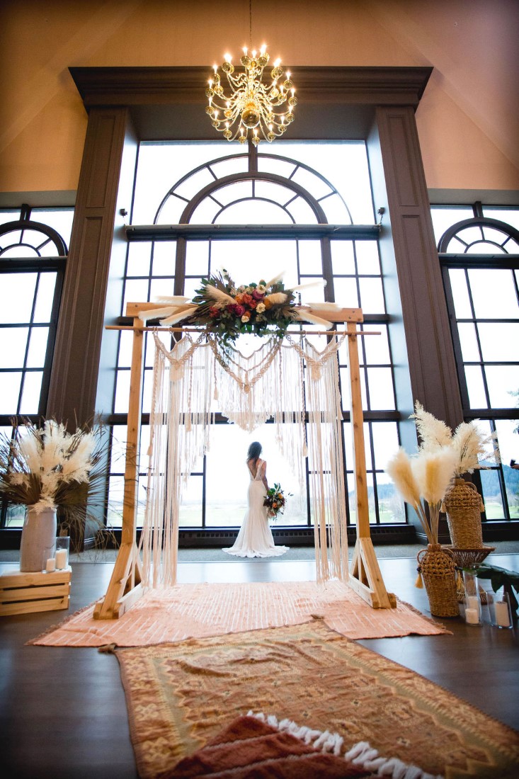 Bohemian Inspired Eleopement featuring rugs, pampas grass and backdrop in front of wall of windows at Swaneset Vancouver