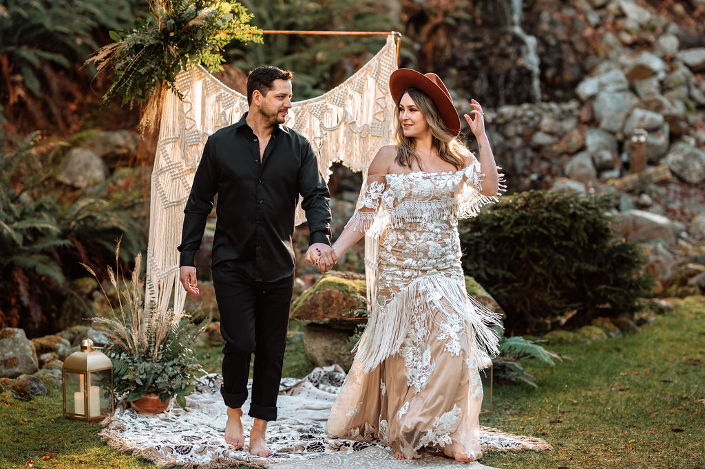 Bride and Groom hold hands and walk towards picnic