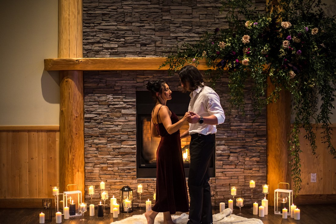 Cozy Elopement Inspiration couple in front of fireplace and candles 