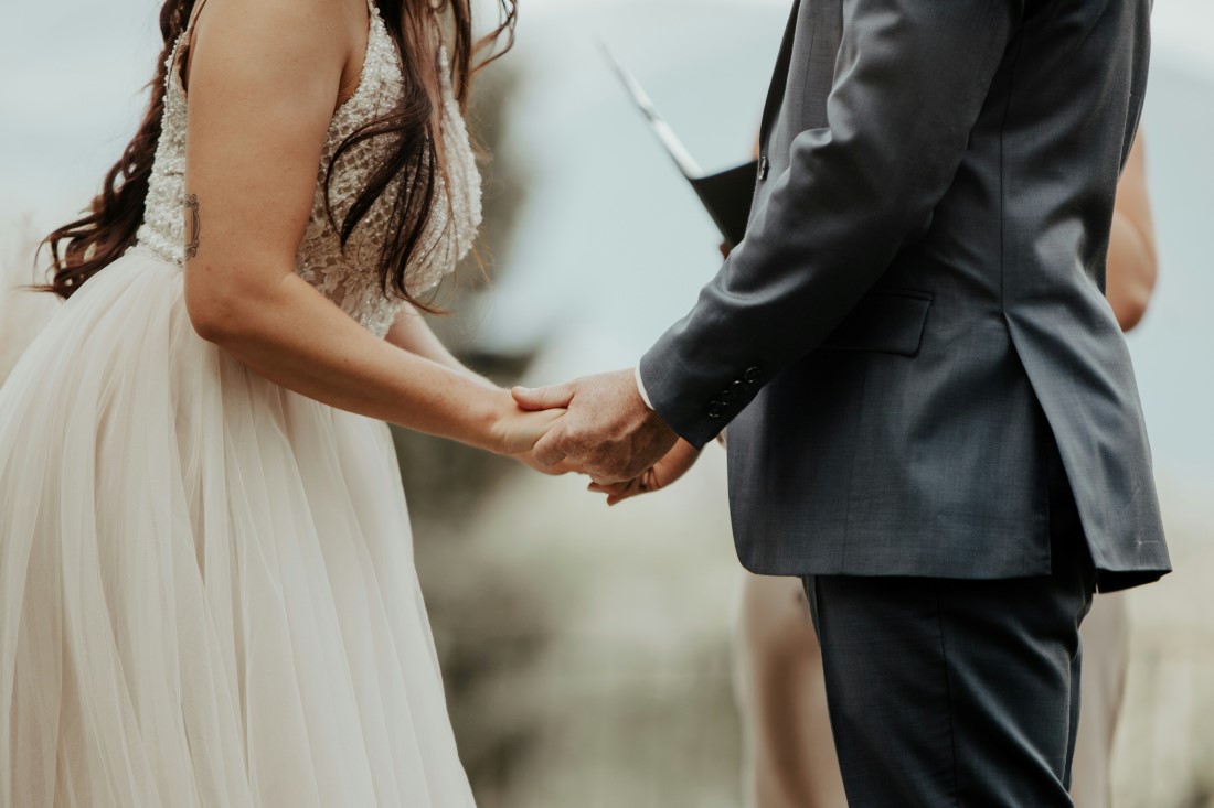 Bride and Groom hold hands while exchanging vows at Blaylock Mansion