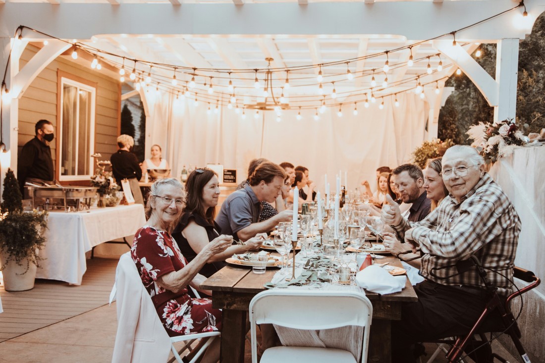 Guests sit at long table at wedding reception