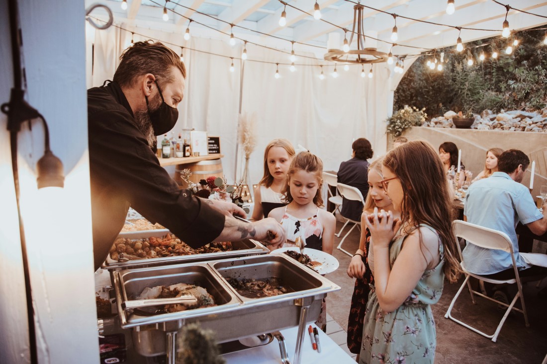 Children at wedding surround food table at reception