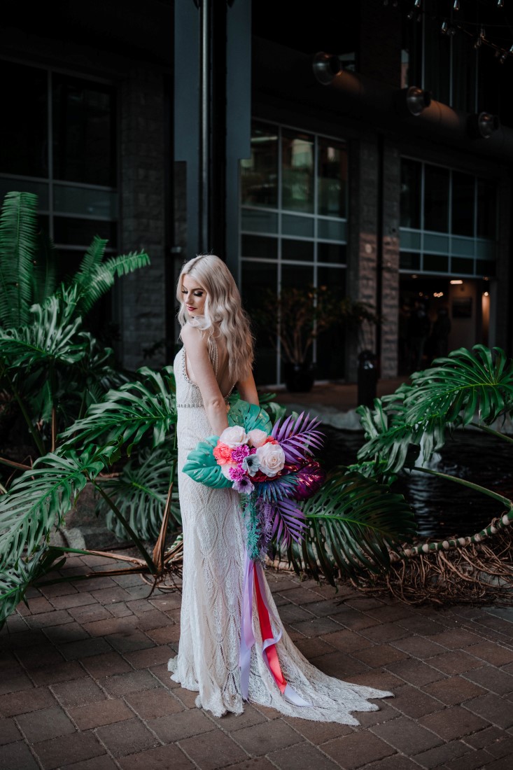 Bride holds bouquet behind her by Megan Maundrell Photography