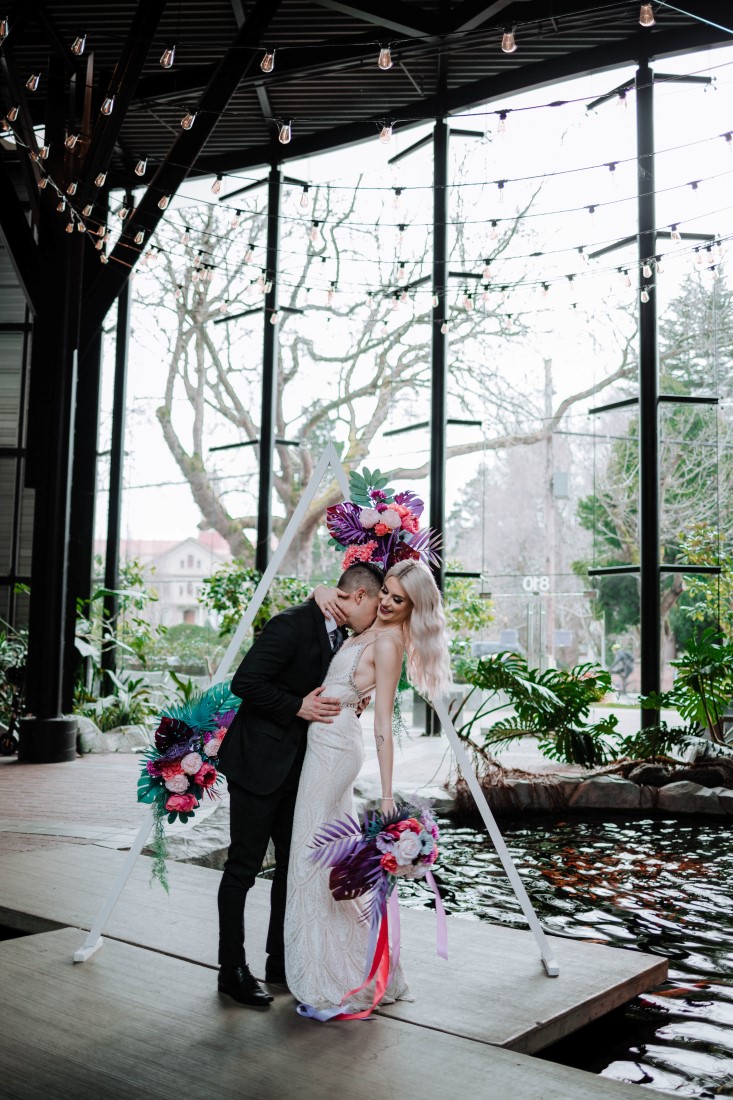 Newlyweds kiss after ceremony in atrium of Parkside Hotel 