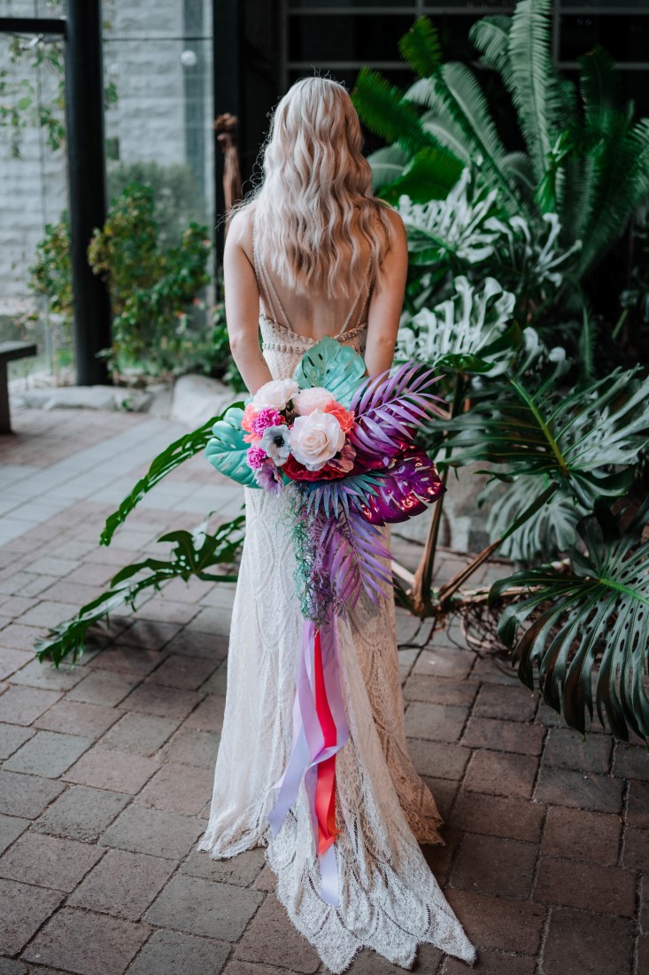 Elopement Giveaway bride holds bouquet behind her back with multicoloured ribbons