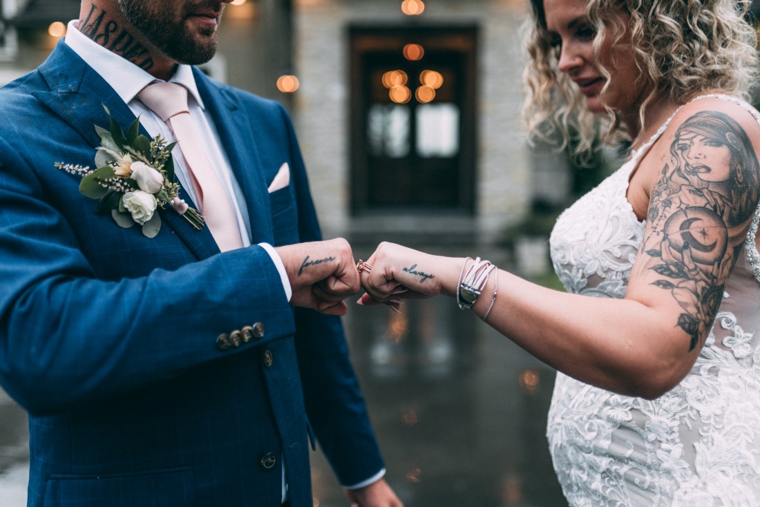 Newlyweds bump fists showing off wedding rings