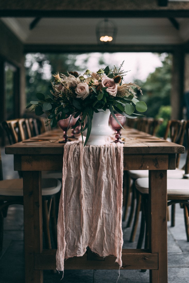 Blush pink runner falls over edge of wood table with pink and white flowers by AJR Designs Vancouver