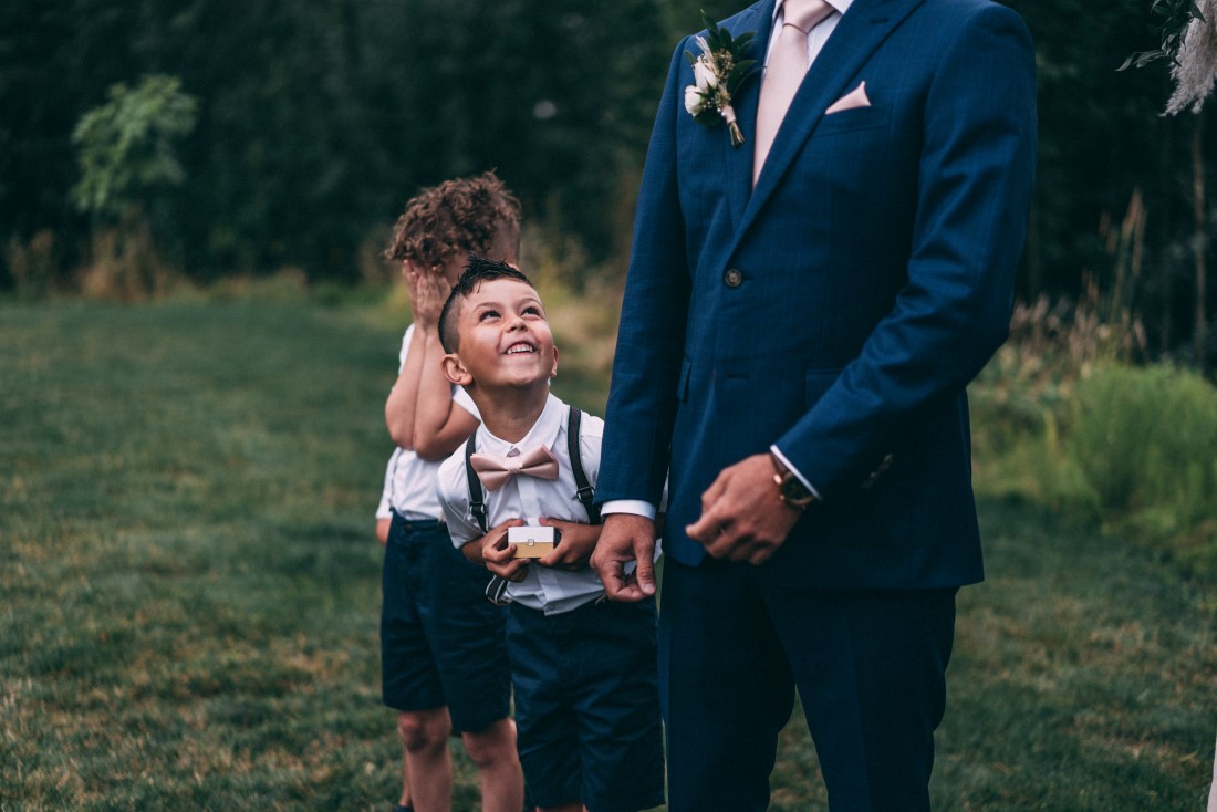 Little boy looks up at groom while they await the bride 